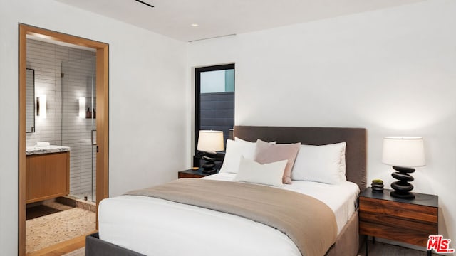 bedroom featuring wood-type flooring and connected bathroom