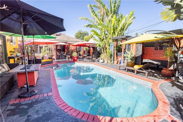 view of pool with a patio and a fire pit