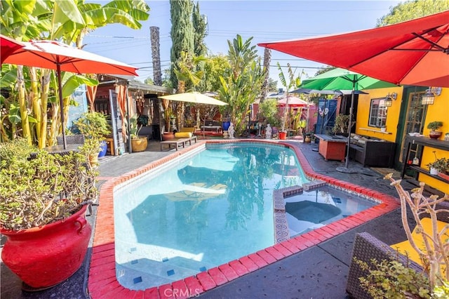 view of swimming pool featuring an in ground hot tub and a patio area