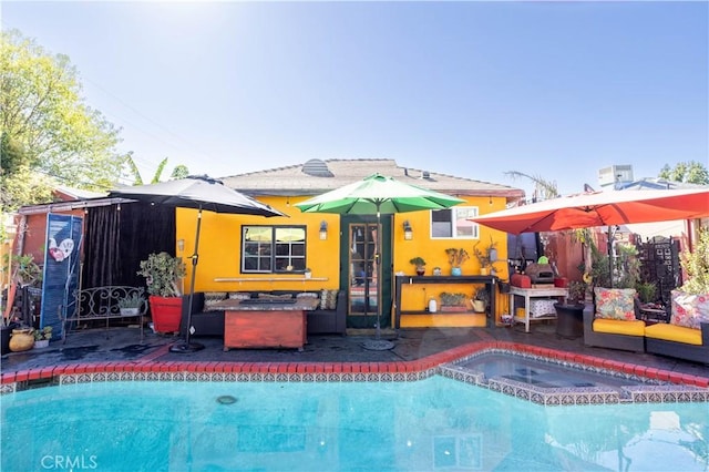 rear view of property with a pool with hot tub and a patio area