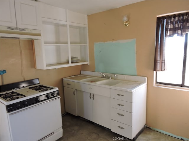 kitchen with sink, white range with gas stovetop, and white cabinets