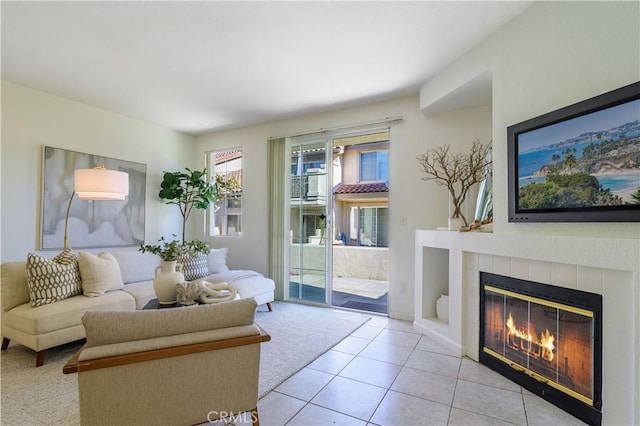 living room featuring a tile fireplace and light tile patterned flooring