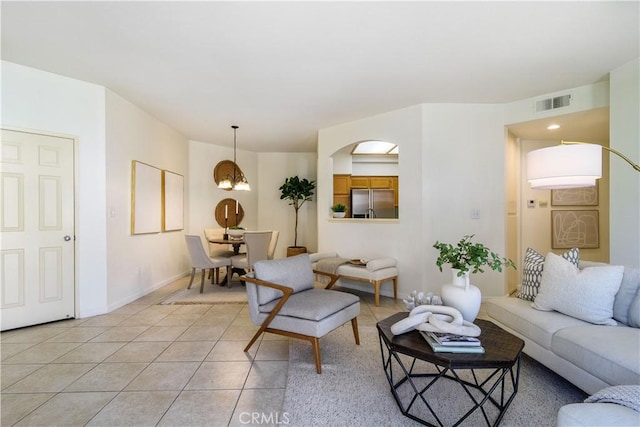 tiled living room featuring a notable chandelier