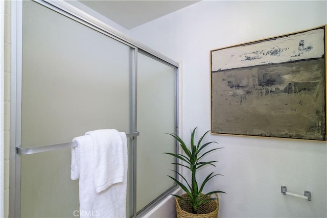 bathroom with combined bath / shower with glass door