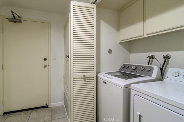 laundry area with cabinets, independent washer and dryer, and light tile patterned floors