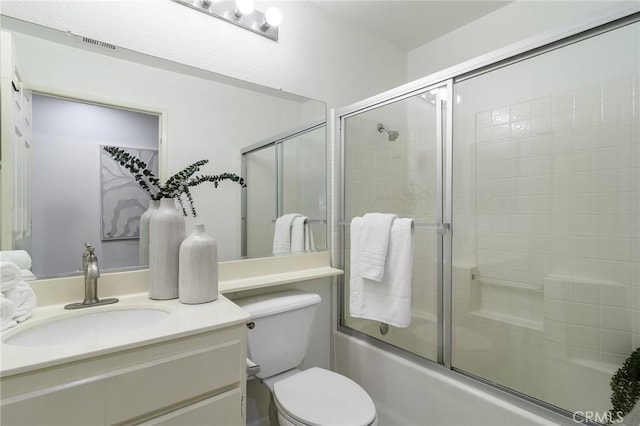 full bathroom with shower / bath combination with glass door, vanity, and toilet