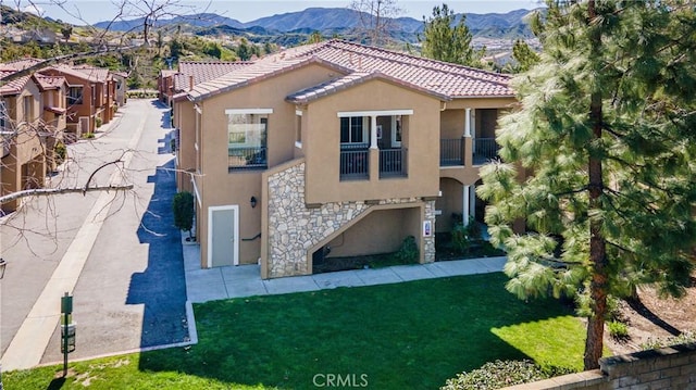 back of house featuring a mountain view and a yard