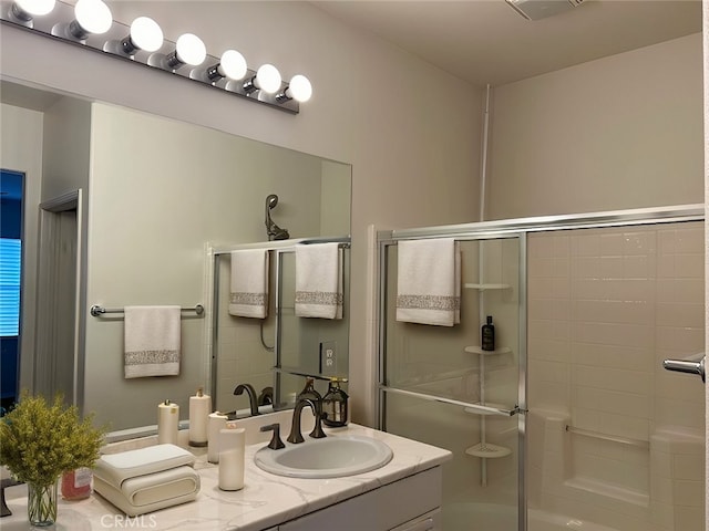 bathroom featuring vanity and a shower with door