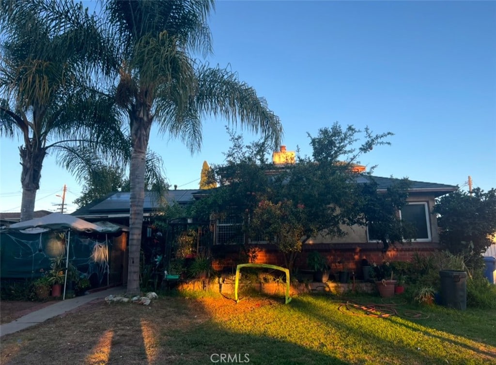 obstructed view of property with a front lawn