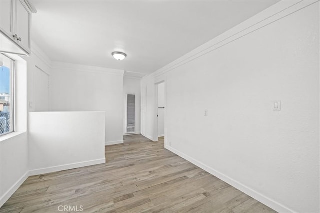 unfurnished room with light wood-type flooring and ornamental molding