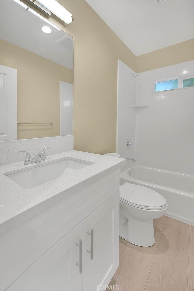 full bathroom with vanity, wood-type flooring, shower / bathtub combination, and toilet