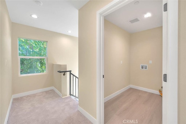 hallway with light colored carpet