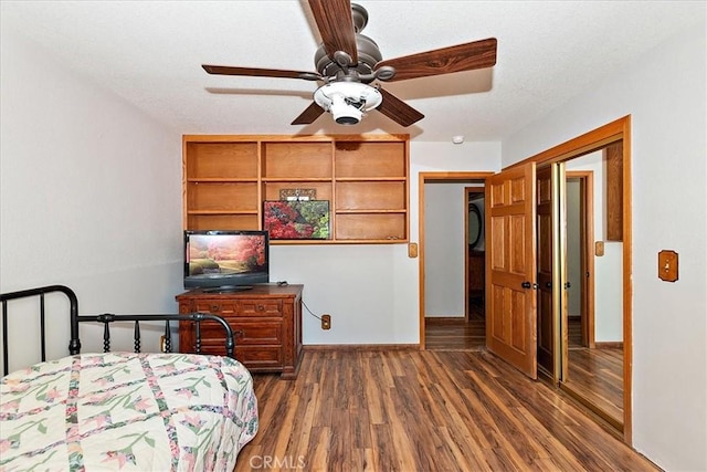 bedroom with dark hardwood / wood-style flooring, a textured ceiling, ceiling fan, stacked washer / dryer, and a closet