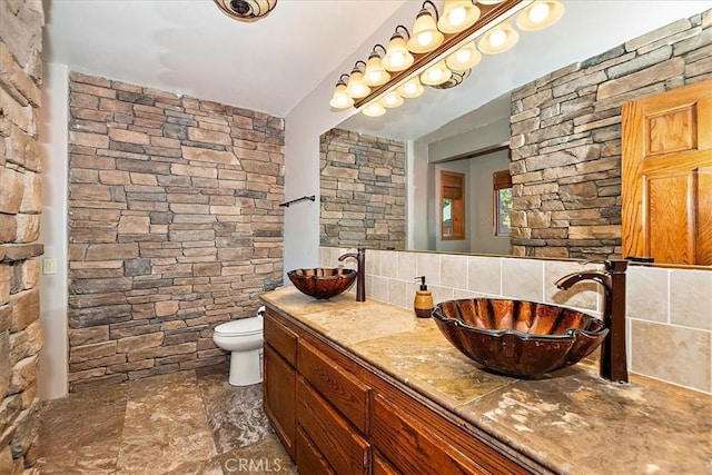 bathroom featuring decorative backsplash, vanity, and toilet