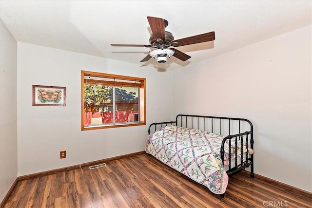 bedroom with dark hardwood / wood-style floors and ceiling fan