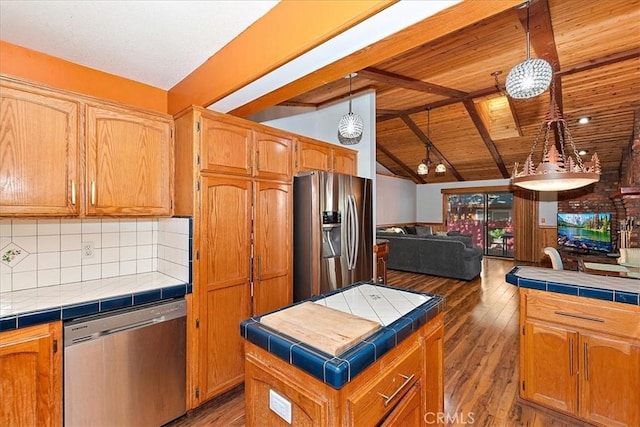 kitchen featuring tile countertops, pendant lighting, lofted ceiling with beams, dark hardwood / wood-style floors, and stainless steel appliances