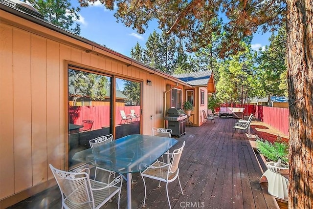 wooden terrace with an outdoor hangout area and grilling area