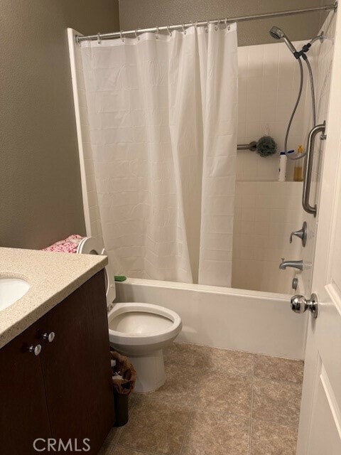 full bathroom with shower / bath combo, vanity, toilet, and tile patterned floors