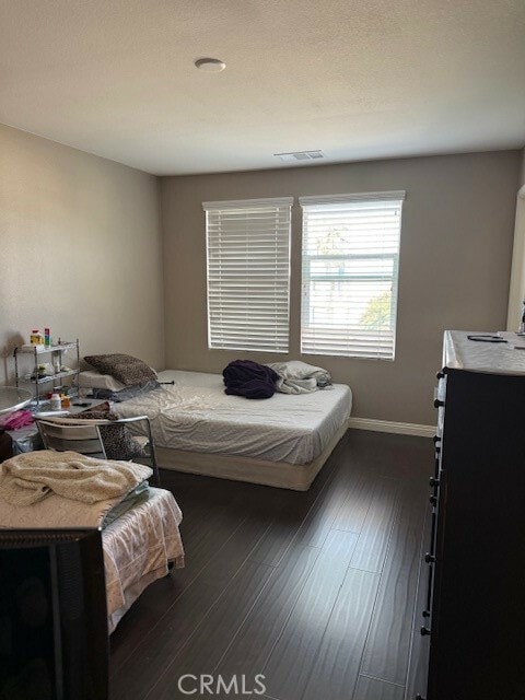 bedroom with dark wood-type flooring