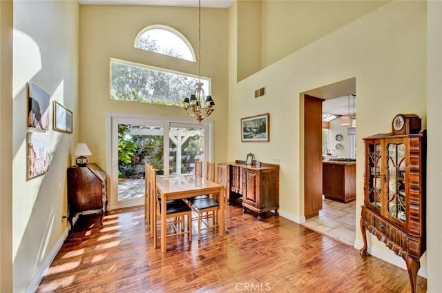 dining area featuring a notable chandelier, light hardwood / wood-style floors, and a healthy amount of sunlight