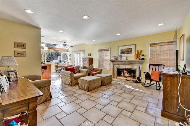 living room with a textured ceiling and ceiling fan