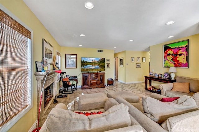 living room with a high end fireplace and light tile patterned floors