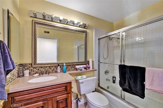 full bathroom featuring decorative backsplash, vanity, combined bath / shower with glass door, and toilet