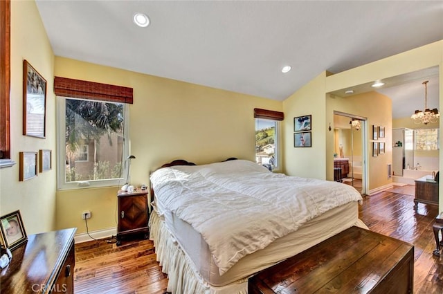 bedroom featuring wood-type flooring, vaulted ceiling, ensuite bath, and a notable chandelier