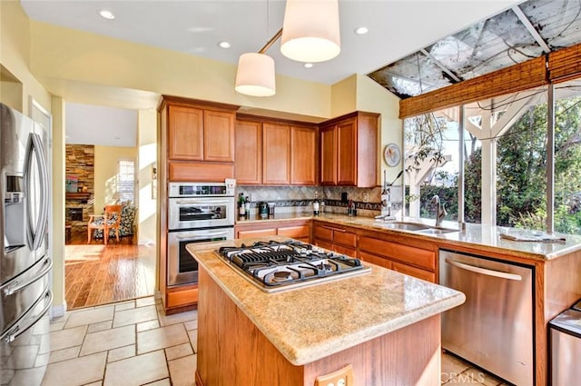 kitchen with sink, a center island, pendant lighting, and appliances with stainless steel finishes