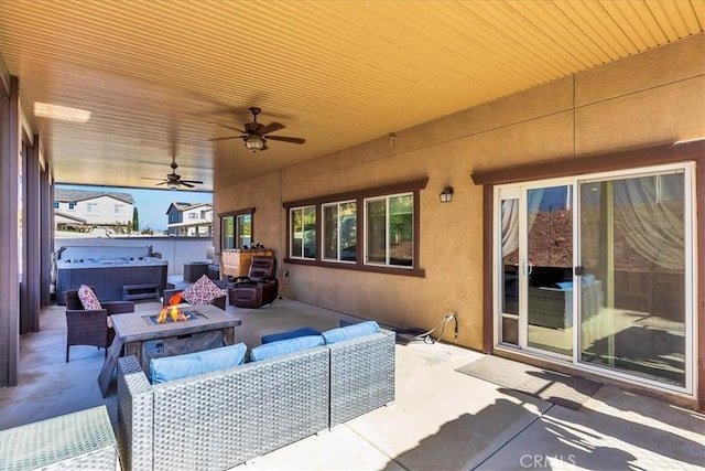 view of patio / terrace featuring ceiling fan, an outdoor living space with a fire pit, and a hot tub