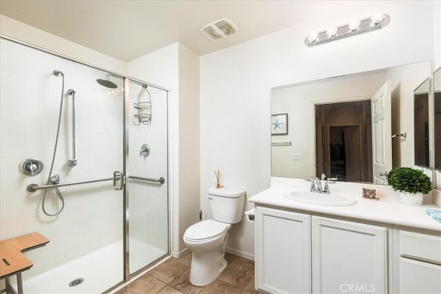 bathroom with tile patterned floors, a shower with door, vanity, and toilet