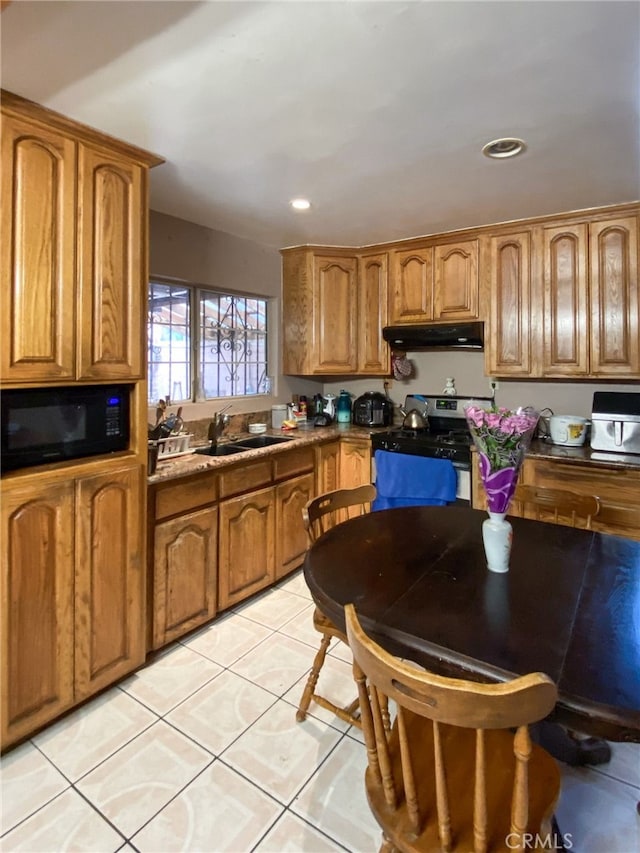 kitchen with light tile patterned floors, black appliances, and sink