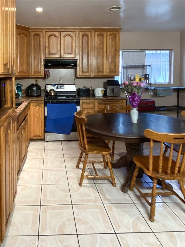 kitchen with light tile patterned floors and range with gas cooktop