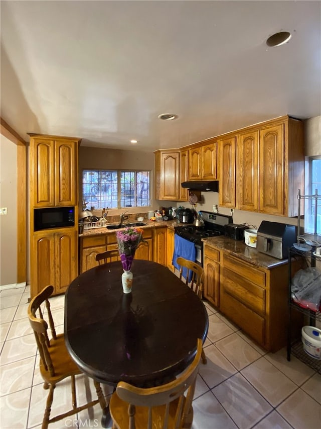 kitchen with black appliances, light tile patterned floors, and sink