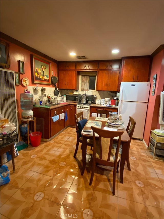 kitchen with backsplash, light tile patterned floors, and stainless steel appliances