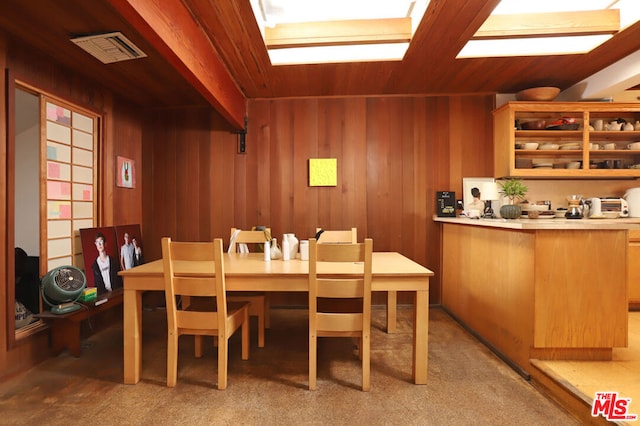 dining room with wood ceiling, wood walls, and light colored carpet