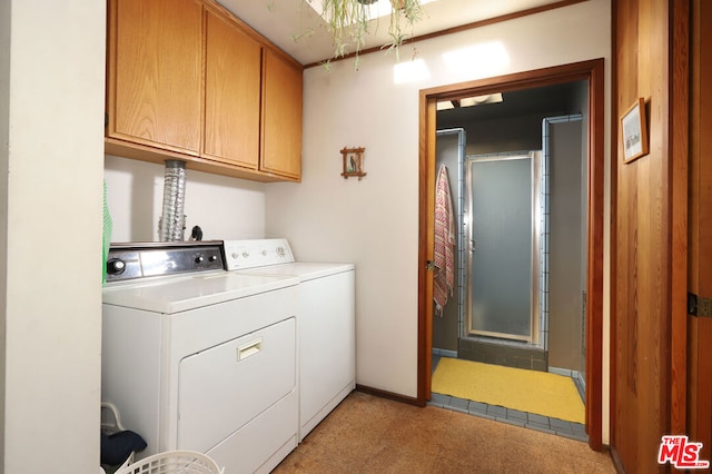 clothes washing area featuring washing machine and dryer, light colored carpet, and cabinets