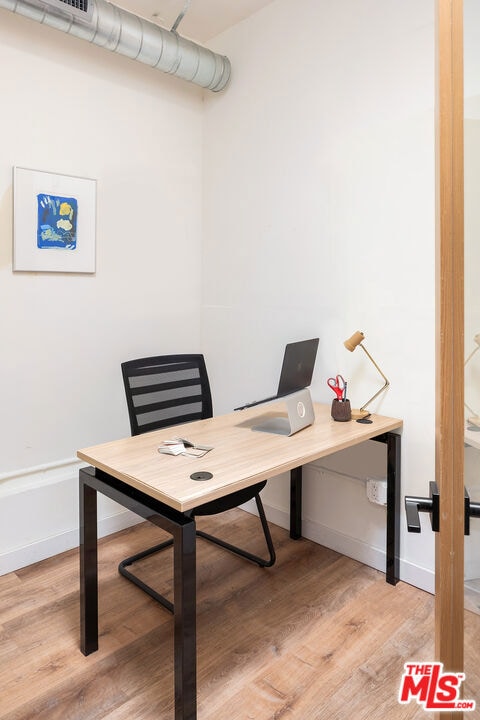 home office with light hardwood / wood-style floors