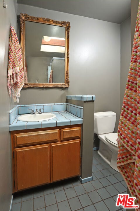 bathroom featuring tile patterned floors, vanity, and toilet