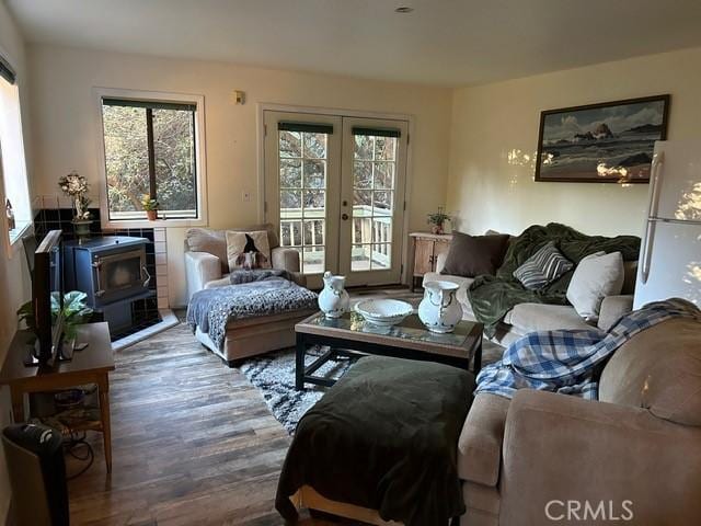 living room with a wood stove, a wealth of natural light, dark hardwood / wood-style flooring, and french doors