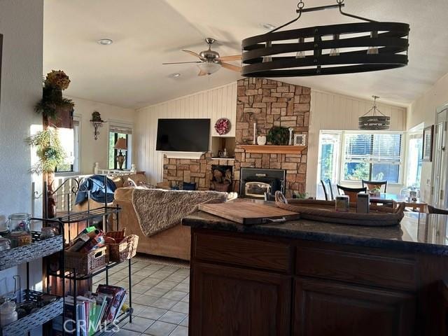 494 Delle Dr, Crestline, CA 92325 - kitchen featuring a stone fireplace, vaulted ceiling, a ceiling fan, dark countertops, and light tile patterned floors