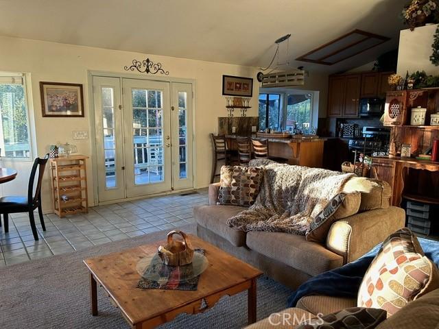 494 Delle Dr, Crestline, CA 92325 - living area featuring light tile patterned flooring, lofted ceiling, and healthy amount of natural light