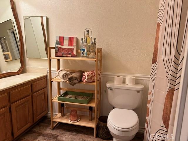 bathroom featuring hardwood / wood-style flooring, vanity, toilet, and a shower with shower curtain