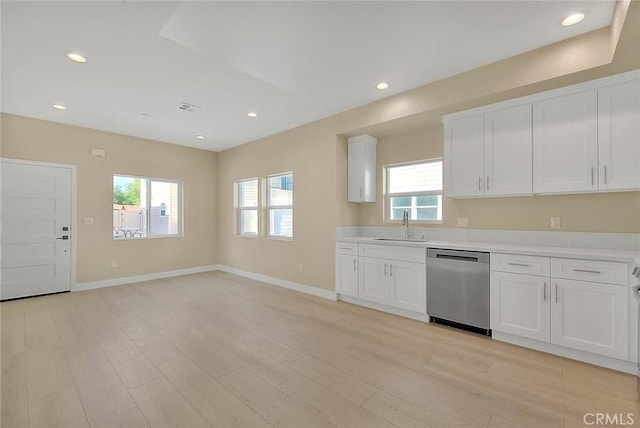 kitchen with white cabinets, dishwasher, a healthy amount of sunlight, and light hardwood / wood-style floors