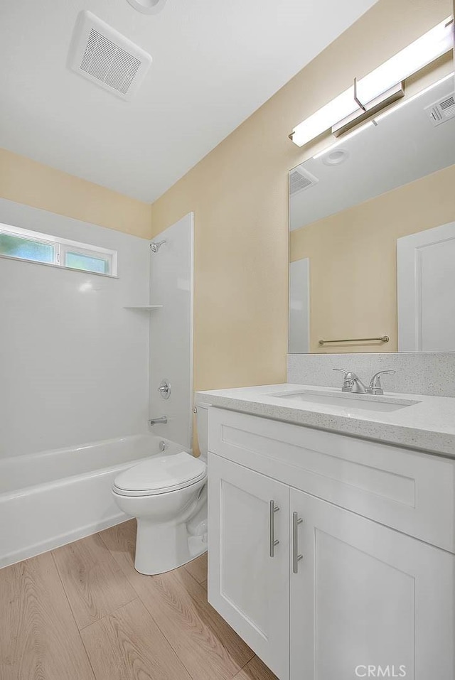 full bathroom featuring hardwood / wood-style flooring, vanity, toilet, and shower / bath combination