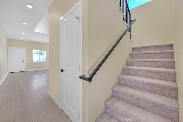 staircase with hardwood / wood-style floors