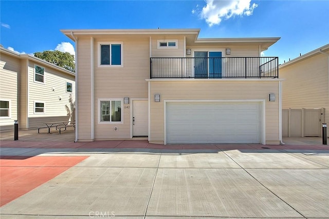 rear view of house with a balcony and a garage