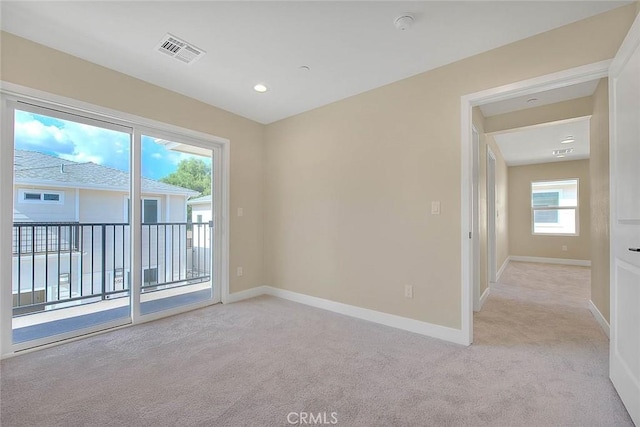 empty room featuring light carpet and plenty of natural light