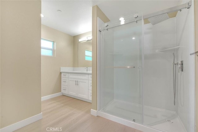 bathroom featuring vanity, wood-type flooring, and walk in shower