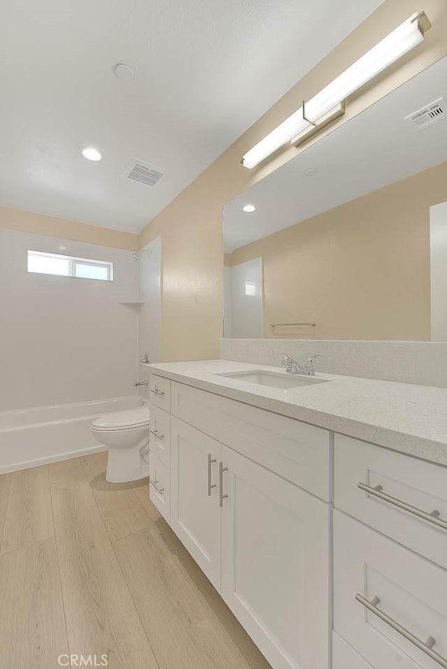 full bathroom with vanity, hardwood / wood-style flooring, toilet, and tub / shower combination